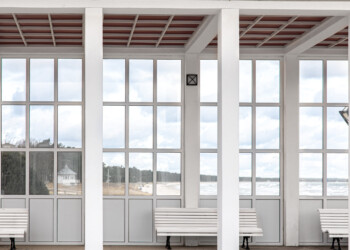 Exterior of a white building with benches overlooking the sea, glass inserts. Exterior of a white building with benches overlooking the sea.