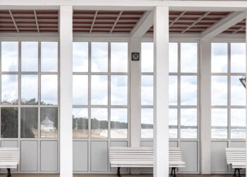 Exterior of a white building with benches overlooking the sea, glass inserts. Exterior of a white building with benches overlooking the sea.
